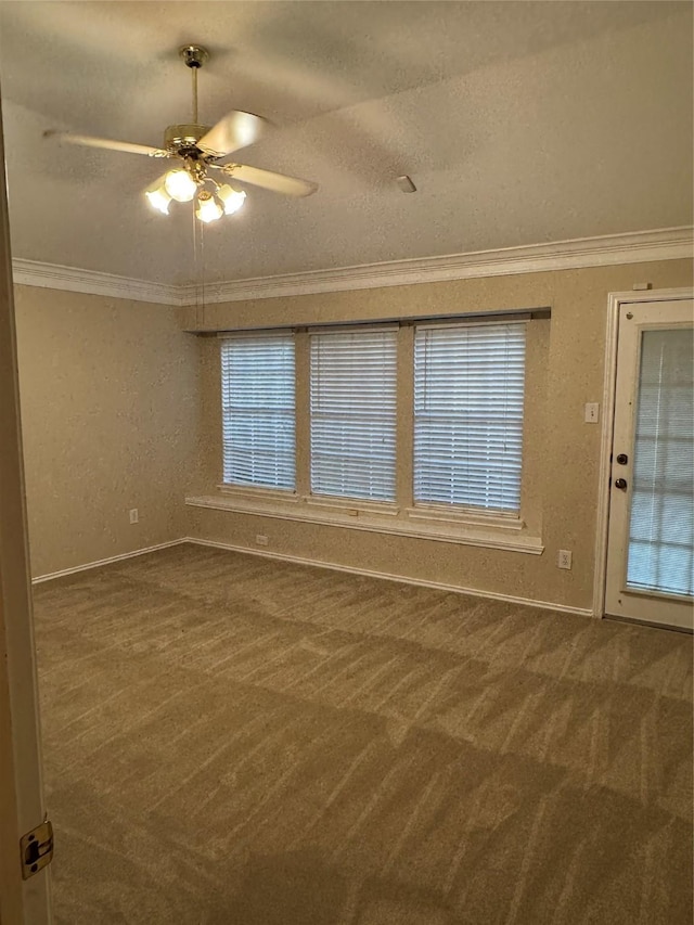 carpeted spare room featuring baseboards, ornamental molding, a textured ceiling, and ceiling fan