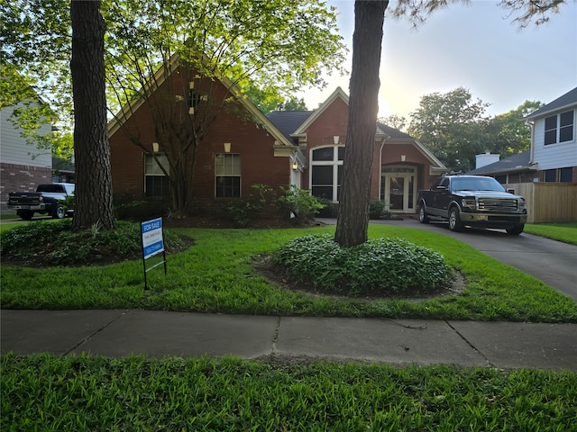 view of front of house featuring brick siding and a front lawn