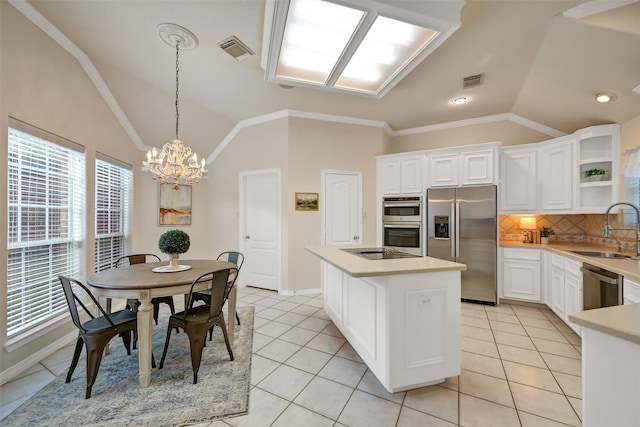 kitchen with a sink, lofted ceiling, a notable chandelier, and stainless steel appliances