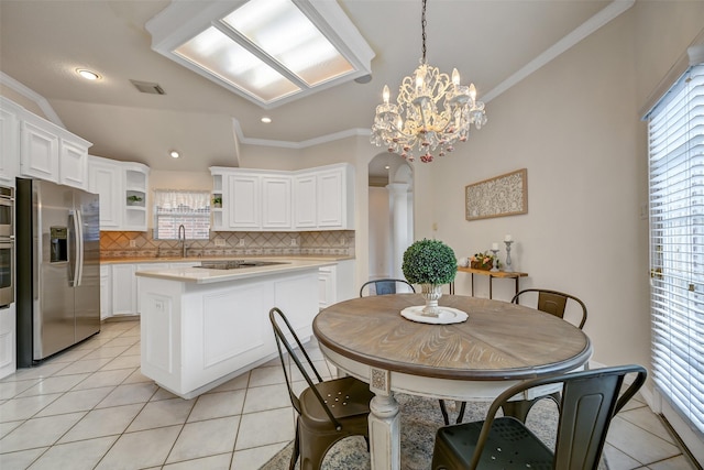 dining room featuring light tile patterned floors, arched walkways, ornamental molding, and a wealth of natural light