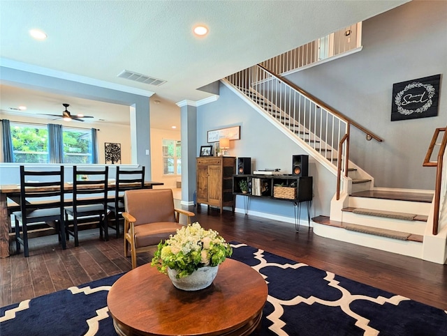 living area with stairway, plenty of natural light, hardwood / wood-style floors, and visible vents
