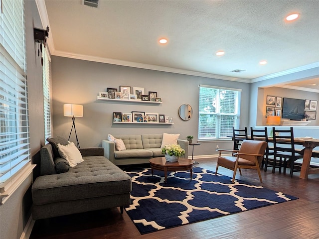 living room featuring crown molding, recessed lighting, baseboards, wood finished floors, and visible vents