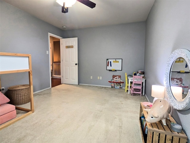 rec room featuring baseboards, ceiling fan, and carpet