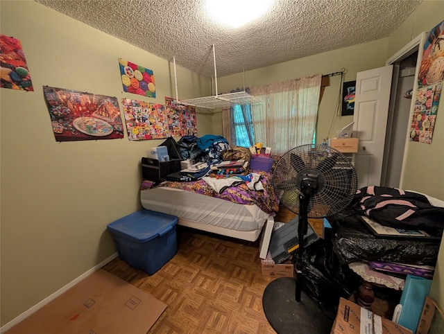 bedroom with baseboards and a textured ceiling