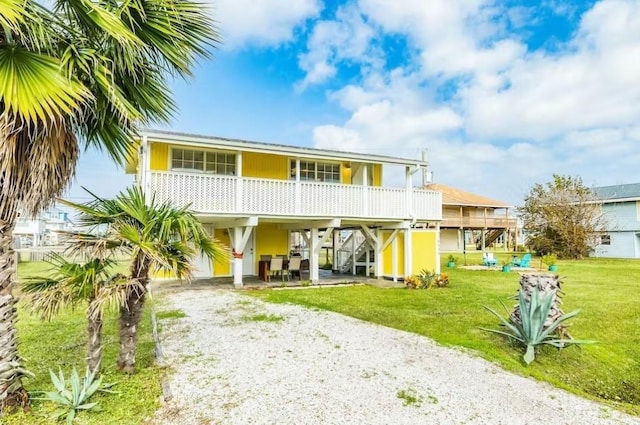 16530 Jean Lafitte Rd, Jamaica Beach, TX 77554 - back of house featuring dirt driveway, a yard, stairway, and a carport