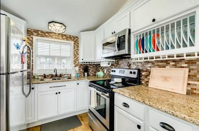 16530 Jean Lafitte Rd, Jamaica Beach, TX 77554 - kitchen with a sink, light stone countertops, stainless steel appliances, and white cabinetry