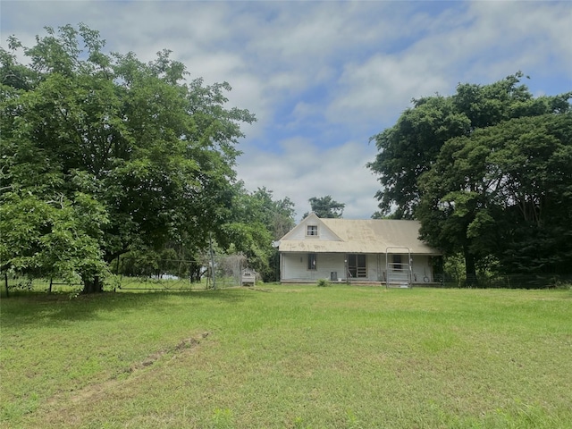 rear view of property with fence and a yard