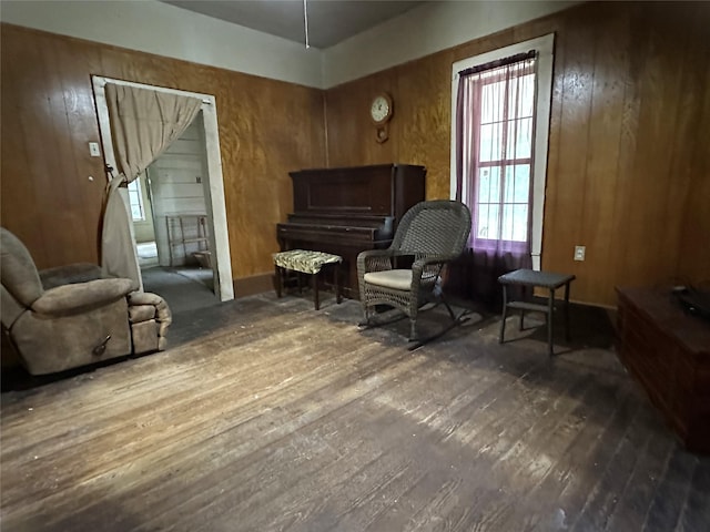 sitting room with wood walls and hardwood / wood-style flooring
