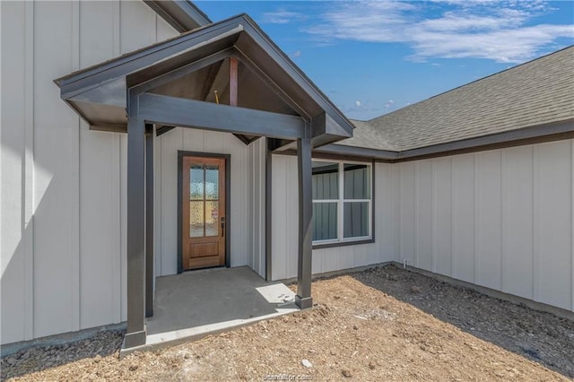 property entrance featuring a shingled roof and board and batten siding