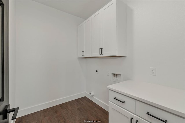 washroom featuring cabinet space, hookup for a washing machine, dark wood finished floors, baseboards, and hookup for an electric dryer