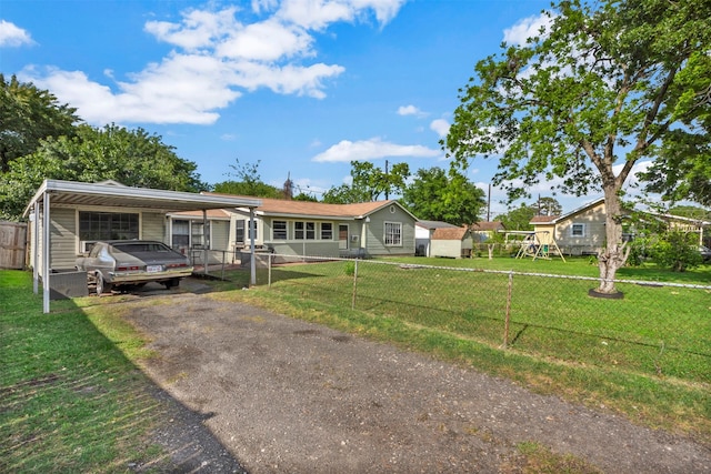 808 Morrell St, Baytown, TX 77520 - view of front of home featuring a front yard, a carport, fence, a playground, and aphalt driveway