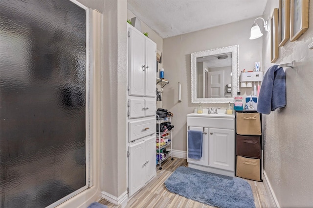 808 Morrell St, Baytown, TX 77520 - full bath with vanity, baseboards, a shower stall, and wood finished floors