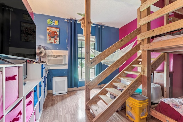 808 Morrell St, Baytown, TX 77520 - stairway featuring a textured ceiling, cooling unit, and wood finished floors