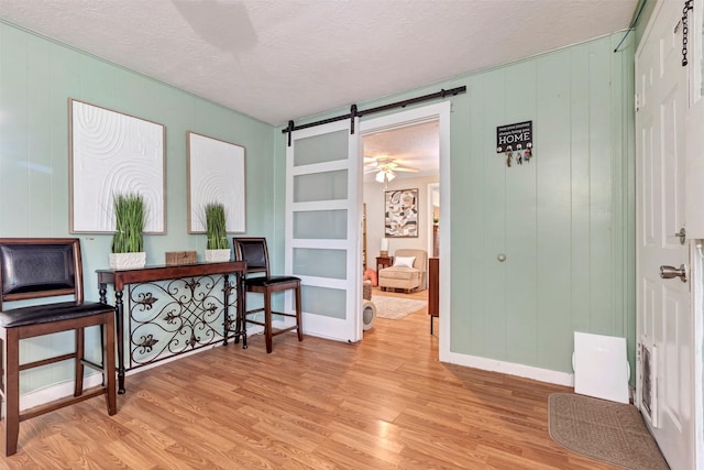 808 Morrell St, Baytown, TX 77520 - living area featuring a textured ceiling, a barn door, built in features, and light wood finished floors