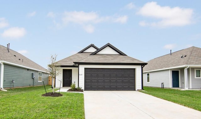 view of front facade featuring an attached garage, a front lawn, and driveway