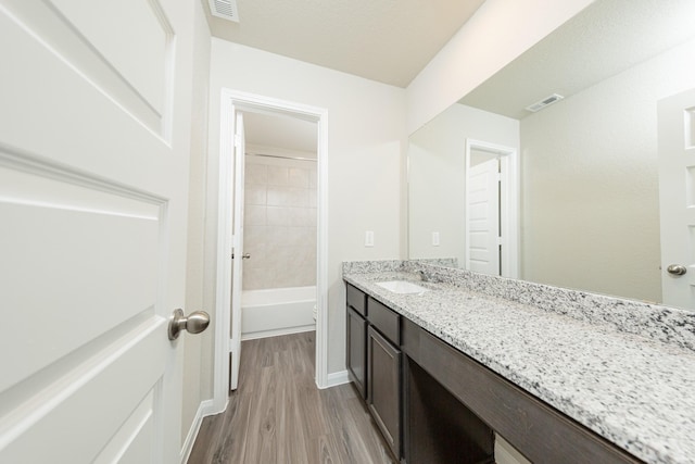 bathroom with visible vents, baseboards, wood finished floors, and vanity