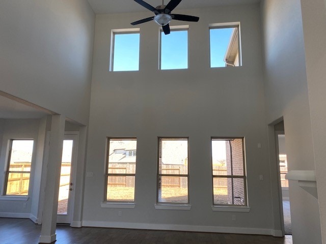 4418 Southpoint Way N, Fulshear, TX 77441 - unfurnished living room with a high ceiling, ceiling fan, baseboards, and dark wood-style flooring