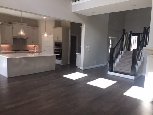 4418 Southpoint Way N, Fulshear, TX 77441 - kitchen featuring oven, light countertops, backsplash, dark wood-type flooring, and a high ceiling