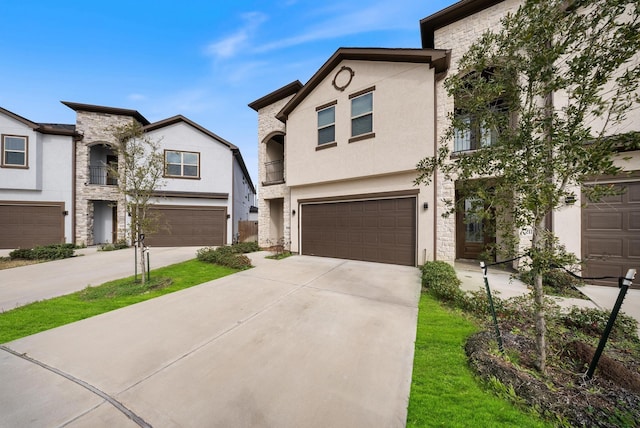 view of front of home with stucco siding, driveway, stone siding, and a garage