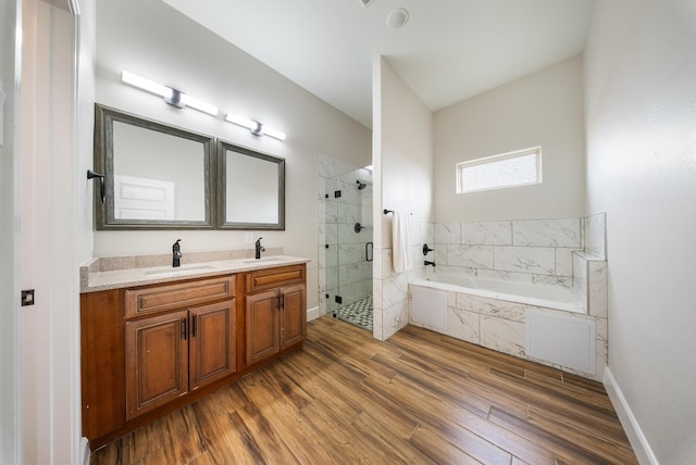 full bath with a sink, a shower stall, a garden tub, and wood finished floors