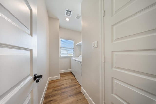 laundry room with laundry area, light wood finished floors, baseboards, visible vents, and washer and clothes dryer