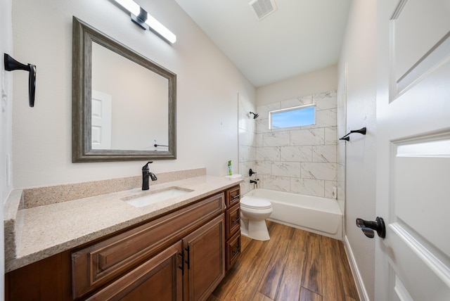 bathroom featuring vanity, toilet, shower / washtub combination, wood finished floors, and visible vents