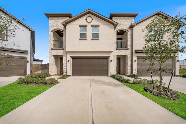 view of front of property with driveway, stucco siding, a balcony, and stone siding
