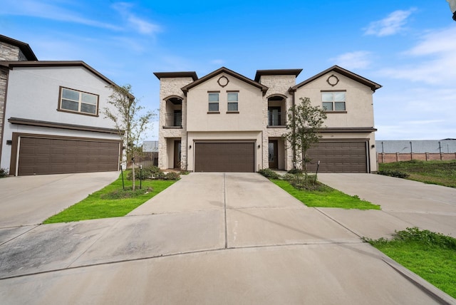 view of front of house featuring concrete driveway, a garage, and stucco siding