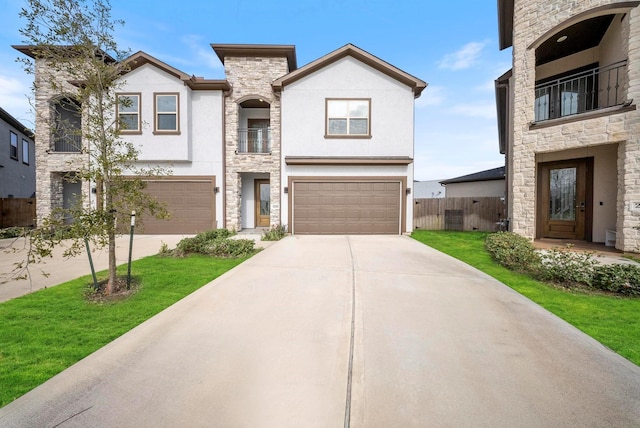 view of front of house featuring a garage, fence, stone siding, stucco siding, and concrete driveway