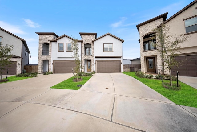 view of front of property with fence, an attached garage, concrete driveway, and stone siding
