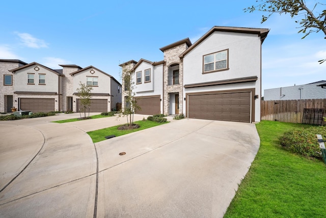 view of front facade with fence, an attached garage, a front lawn, stucco siding, and driveway