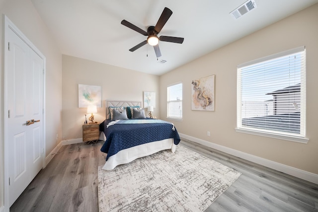 bedroom with ceiling fan, baseboards, visible vents, and light wood-style flooring