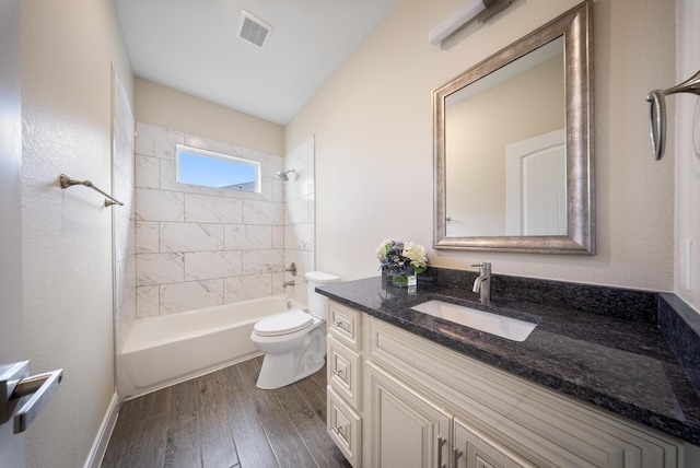 bathroom with visible vents, wood finished floors, shower / washtub combination, vanity, and toilet