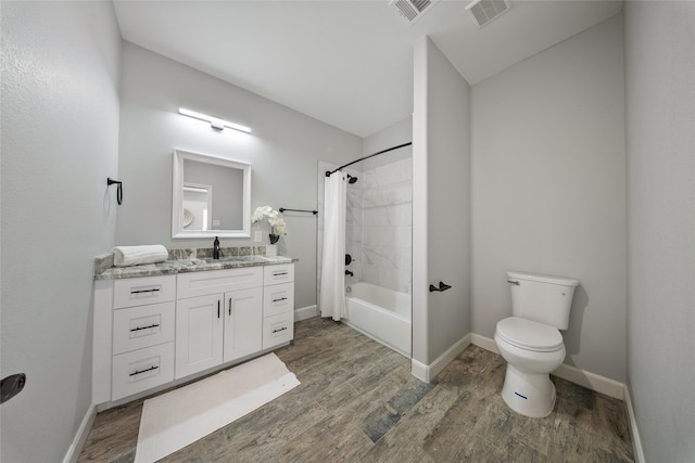 bathroom featuring visible vents, shower / tub combo, wood finished floors, and toilet
