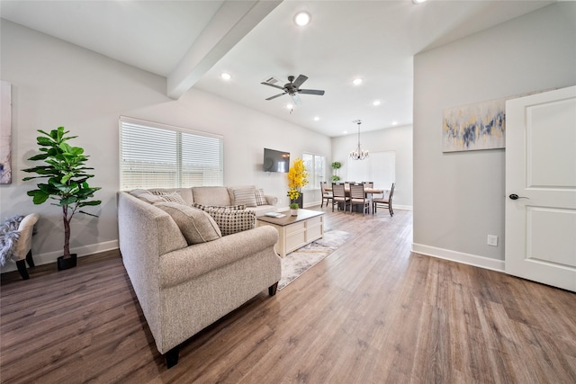 living area with ceiling fan with notable chandelier, recessed lighting, baseboards, wood finished floors, and beamed ceiling