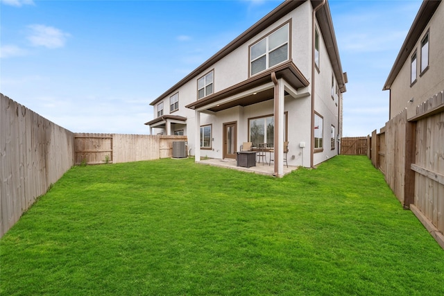 back of property with central AC, a lawn, stucco siding, and a patio