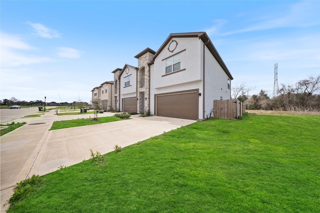 view of front of house featuring driveway, a front yard, a garage, fence, and stucco siding