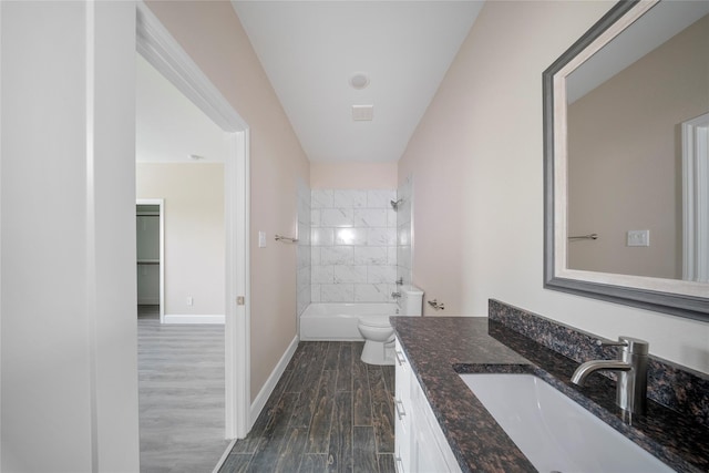 full bath featuring wood finished floors, shower / washtub combination, vanity, baseboards, and toilet