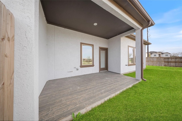 exterior space featuring fence, stucco siding, and a yard