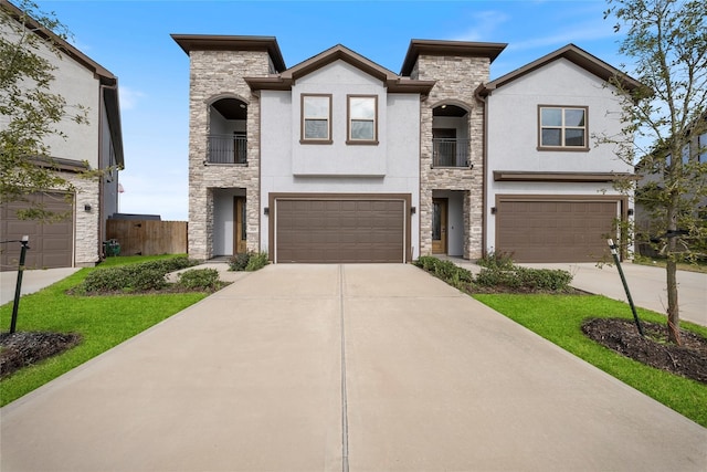 view of front of home featuring an attached garage, stucco siding, a balcony, and stone siding