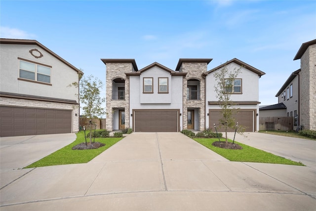 view of front of property with fence, an attached garage, driveway, and stucco siding