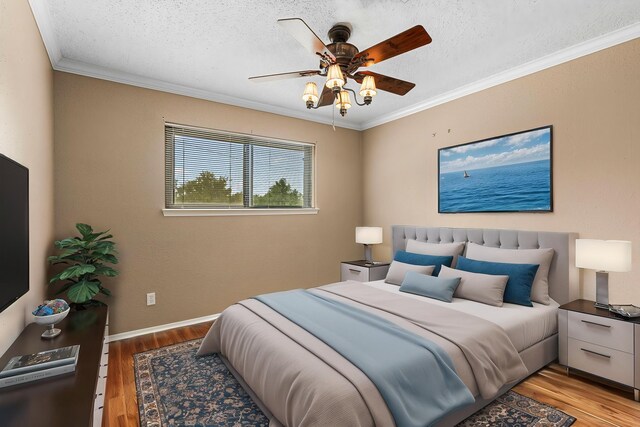 3749 Wakeforest St, Houston, TX 77098 - bedroom with light wood finished floors, ornamental molding, a textured ceiling, ceiling fan, and baseboards