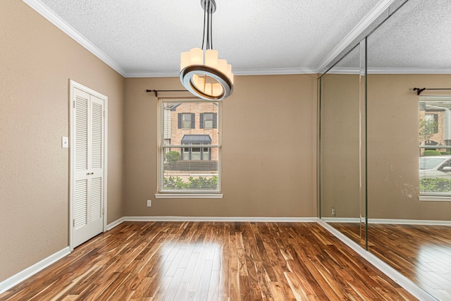 3749 Wakeforest St, Houston, TX 77098 - empty room with a textured ceiling, wood-type flooring, crown molding, baseboards, and a chandelier