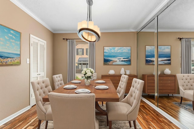3749 Wakeforest St, Houston, TX 77098 - dining area with hardwood / wood-style floors, crown molding, baseboards, and a chandelier