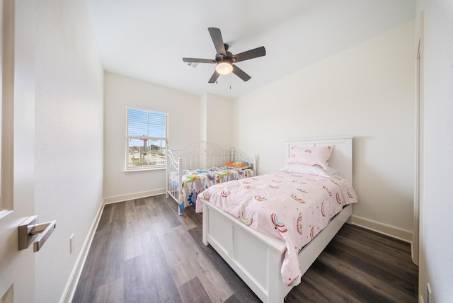 bedroom with a ceiling fan, baseboards, and dark wood finished floors