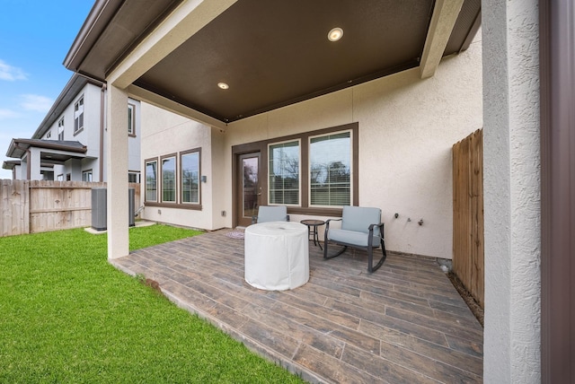 exterior space featuring a patio area, central AC, fence, a yard, and stucco siding