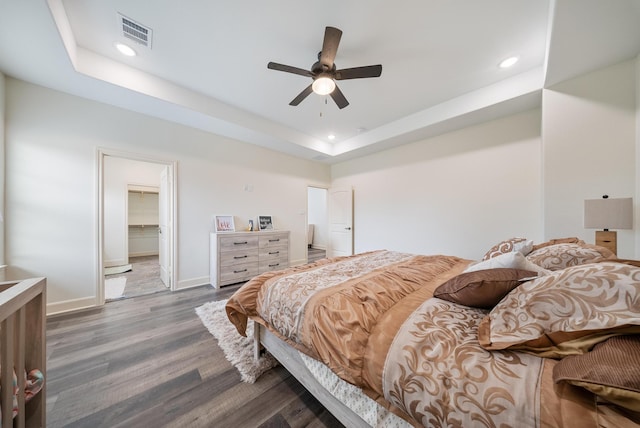 bedroom featuring recessed lighting, baseboards, wood finished floors, and a tray ceiling