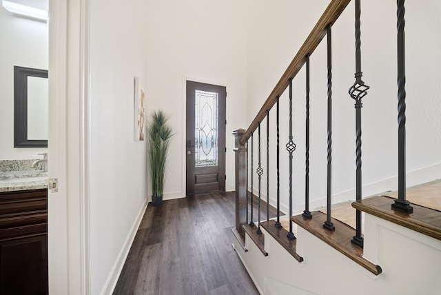 entryway featuring baseboards, dark wood finished floors, and stairway