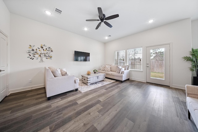 living room with baseboards, a ceiling fan, dark wood-type flooring, and visible vents