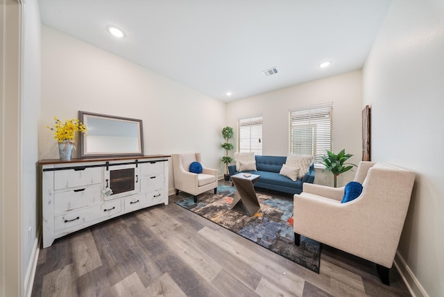 living area featuring visible vents, recessed lighting, baseboards, and wood finished floors